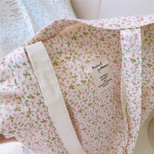 Detail der floralen Canvas-Tragetasche mit rosa Blumenmuster und gewebtem Etikett