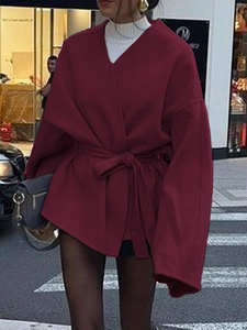 Détail du manteau en laine bordeaux avec ceinture à nouer et manches larges élégantes