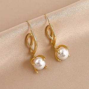 Elegant gold pearl drop earrings on silk fabric with a geometric minimalist design