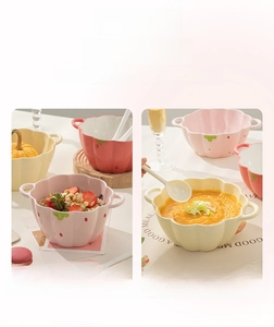 Close-up of strawberry and pumpkin shaped ceramic bowls with scalloped edges and handles
