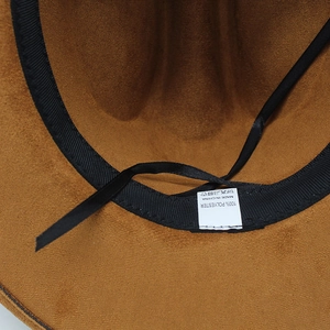 Macro detail of the brown faux suede cowboy hat interior with adjustable strap and sweatband
