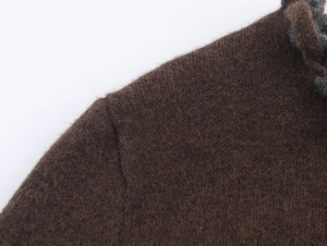 Vue détaillée de la couture d'épaule et texture du tissu du gilet en maille marron foncé