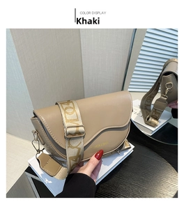 Close-up of khaki PU leather saddle bag featuring a wide embroidered letter pattern strap