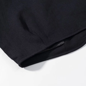 Detail of premium black twill fabric with precision stitching and curved hemline