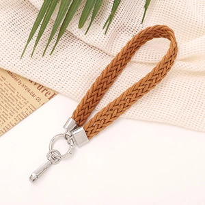 Close-up of brown braided wrist strap with silver metal lobster clasp on a flat lay background