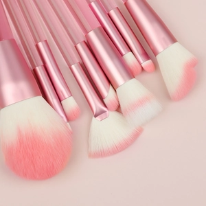 Macro detail of 9-piece makeup brush set with transparent pink handles and soft bristles