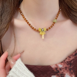 Close-up of resin beaded necklace featuring a fairy pendant and green leaf detail