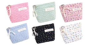 Detailed view of tweed cosmetic pouches with pearl bow charms in six assorted colors