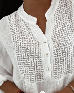 Close-up of white shirt with crochet lace panel, V-neckline and button details