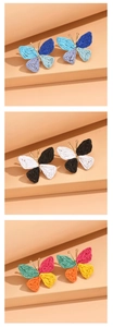 Detailed view of handmade raffia butterfly earrings in blue, white, and multi-color options