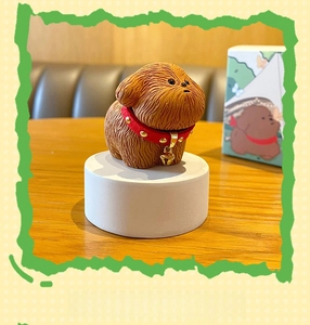 Detail view of a resin Schnauzer figurine featuring brown fur texture and a red studded collar
