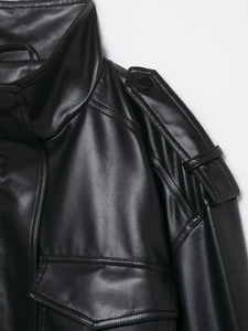 Detail der schwarzen Kunstlederjacke mit Stehkragen, Schulterklappen und feiner Textur