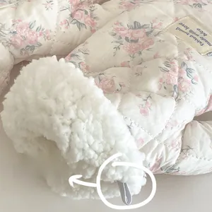 Macro detail showing warm sherpa fleece lining and quilted floral fabric of the gloves