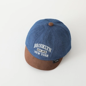 Detailed close-up of blue denim and brown suede baseball cap with Brooklyn embroidery