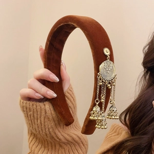 Detail of brown velvet headband with vintage ethnic gold bells and tassel charms