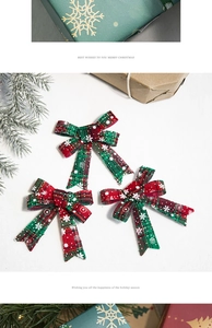 Close-up of three red and green plaid Christmas bows with white snowflake patterns