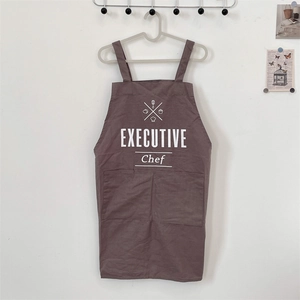 Detail of dark brown chef apron featuring large double pockets and executive print