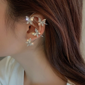 Macro view of crystal butterfly ear cuffs featuring silver metal and sparkling zircons