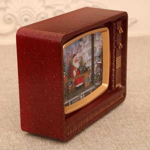Detail of red vintage TV music box with snow scene, Santa and gold glitter finish