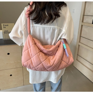 Detail of pink quilted tote bag showing large capacity and soft fabric texture on a model