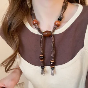 Collier rétro en tissu de lin avec perles en bois et pompons bruns style bohème