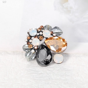 Vintage crystal brooch with multi-colored teardrop gems and silver-grey metal leaves