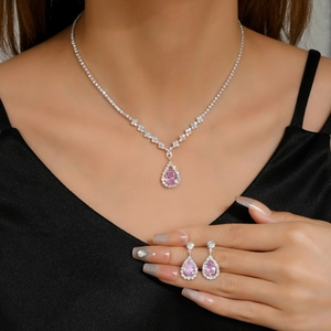 Detail of pink teardrop zircon necklace and earrings set with micro-pave diamond accents
