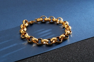 Detail of a chunky gold-plated stainless steel Rolo chain bracelet on blue background
