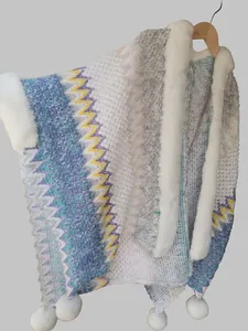 Detail of knitted ethnic shawl featuring faux rabbit fur collar and colorful zigzag patterns