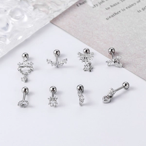 Macro detail of silver stainless steel cartilage studs with zircon heart and crown shapes