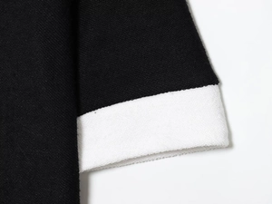 Détail des poignets tricotés contrastés noir et blanc avec une texture tissée de qualité
