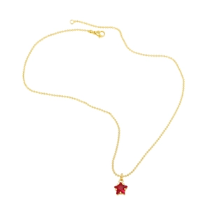 Close-up of a minimalist gold bead chain necklace with a faceted red star pendant