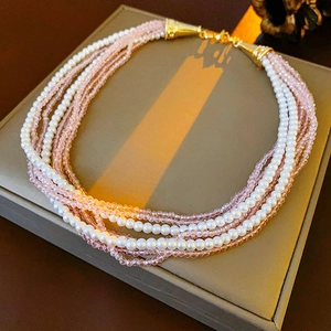 Detail of bohemian multilayer necklace with white pearls and pink faceted crystal beads