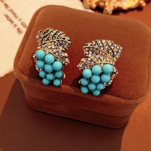 Vintage gold leaf and turquoise grape cluster earrings with crystals on velvet