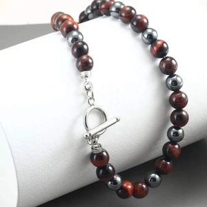 Detail of beaded necklace with tiger eye stone, hematite, and silver toggle clasp finish