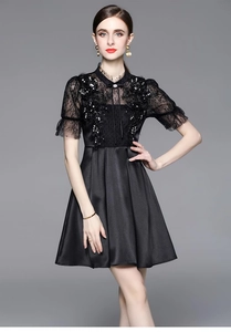 Detail view of black lace dress featuring intricate sequined floral patterns and short sleeves