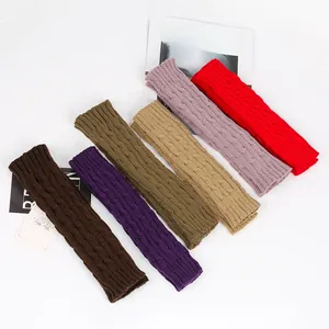 Flat lay of cable knit arm warmers in various colors with magazine decor
