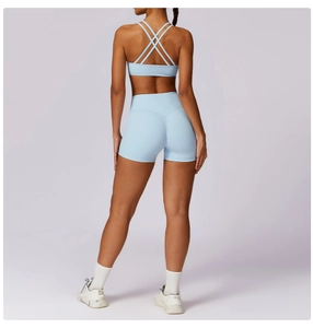 Rear view detail of light blue high-waisted fitness shorts and cross-back sports bra set