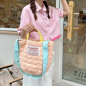 Détail du sac cabas matelassé pêche avec poignées jaunes et surpiqûres en forme de cœur