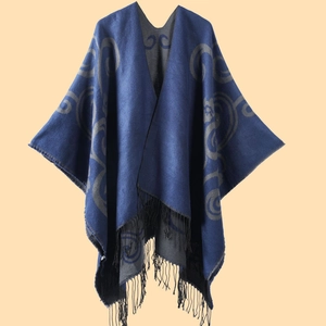 Detail of soft blue and grey cashmere-like shawl featuring tribal patterns and fringes