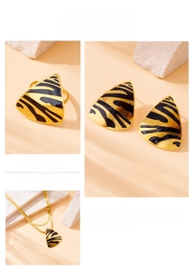 Detail of tiger pattern jewelry set with triangle pendant necklace, ring and earrings