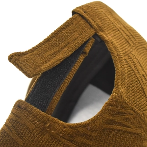 Detail of adjustable velcro strap on brown corduroy baseball cap with ribbed texture