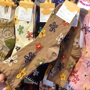 Detailed close-up of retro floral embroidered cotton socks with colorful flower patterns