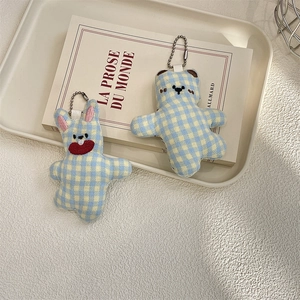 Close-up of cute plaid teddy bear and rabbit plush charms with silver bead chains
