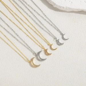 Macro detail of gold and silver crescent moon pendants with pavé set cubic zirconia