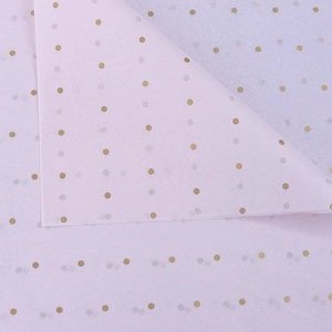 Close-up of purple tissue paper with golden polka dots for elegant floral gift wrapping