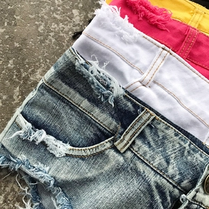 Dettaglio di pantaloncini di denim con texture strappata e bordi grezzi in vari colori