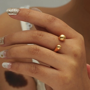 Polished gold adjustable open ring with minimalist double ball design worn on finger