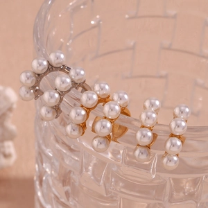 Vue macro de clips d'oreilles en perles dorées 18K sur le rebord d'un verre ciselé