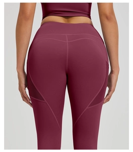 Close-up of wine red yoga leggings featuring mesh panels and push-up seam design